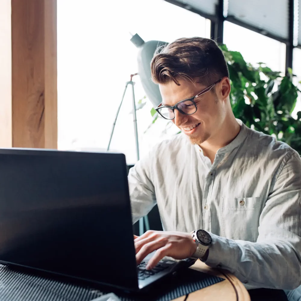 attractive-businessman-eyeglasses-working-laptop-typing-spending-time-cafe